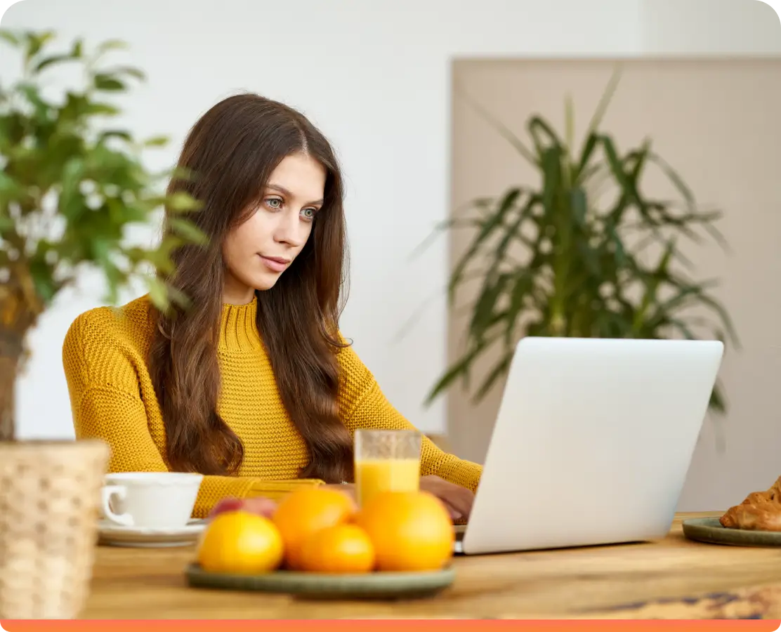 Woman in orange shirt working on her company idea
